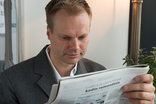 a man reading news paper with reading glasses